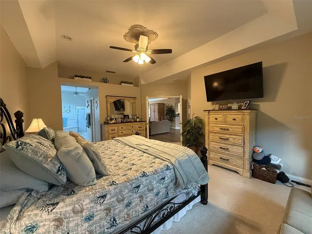 a bedroom with a bed and a flat tv screen on dresser