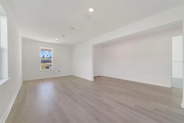 an empty room with wooden floor and window