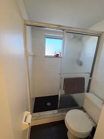 a bathroom with a toilet and a shower