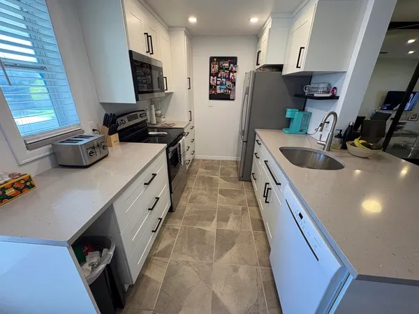 a kitchen with stainless steel appliances granite countertop a sink and a stove