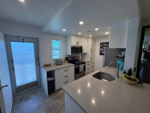 a kitchen with sink a refrigerator and cabinets
