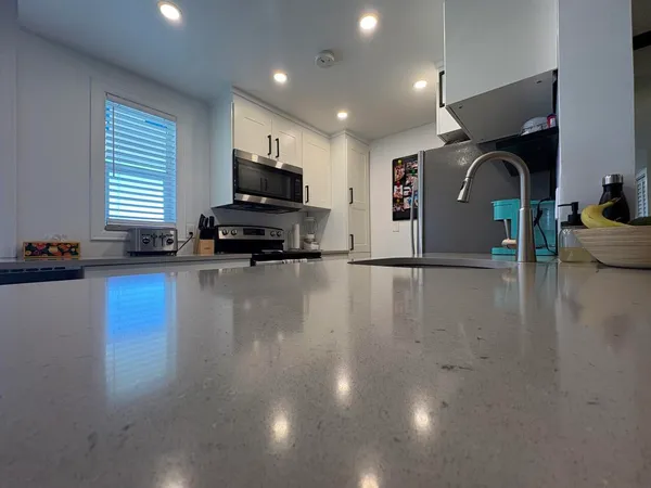 a view of kitchen with sink microwave and cabinets