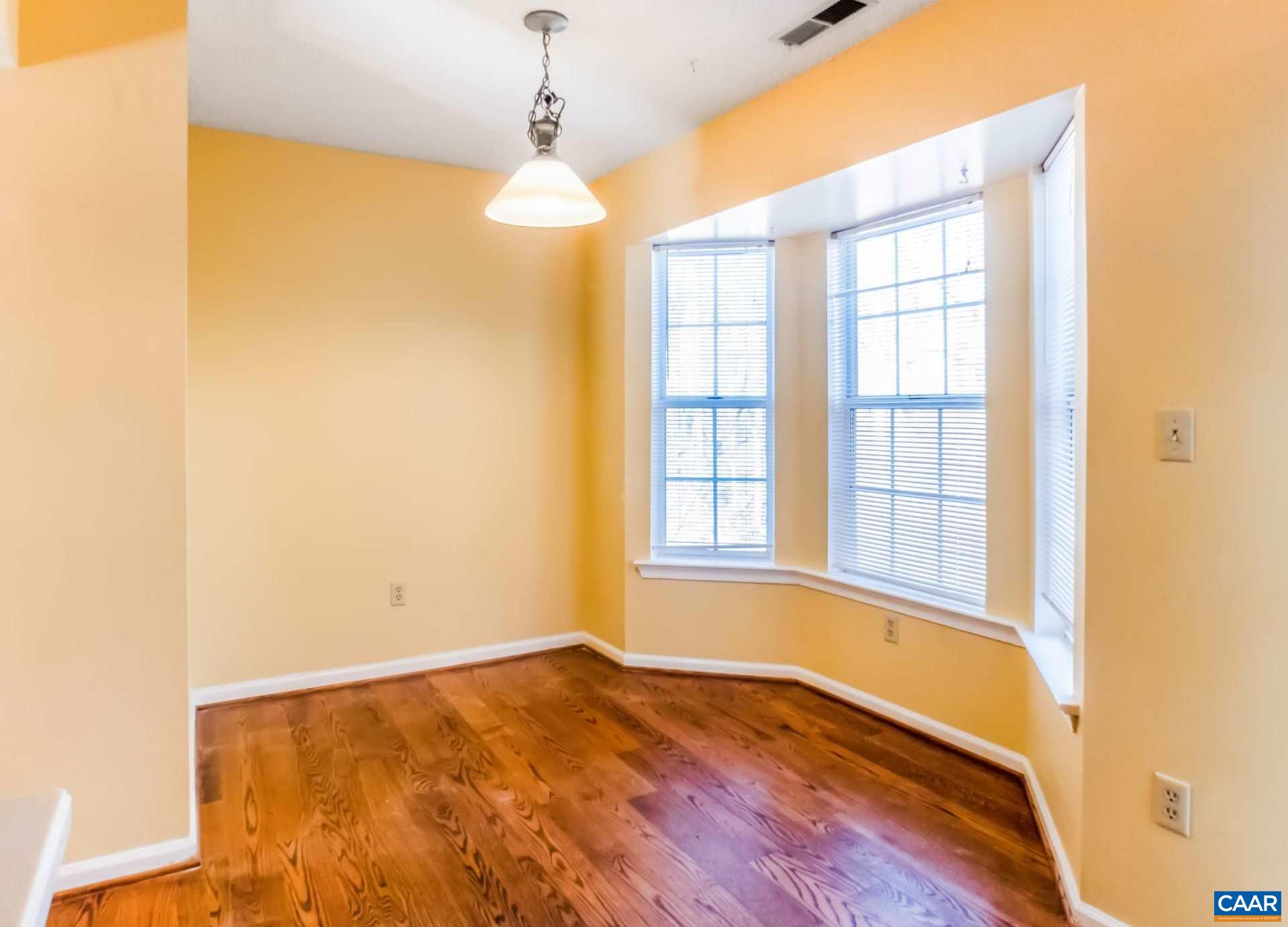 300 Westfield Road Charlottesville, VA 22901 - Photo 7 of 26 an empty room with wooden floor and windows