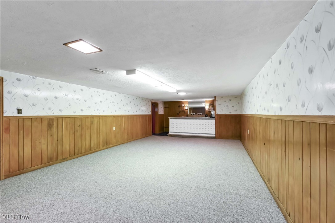 4908 East Pleasant Valley Road Independence, OH 44131 - Photo 18 of 31 View of massive carpeted and paneled basement rec room toward the built in bar