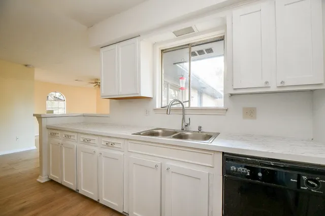a kitchen with stainless steel appliances granite countertop a sink a stove and cabinets