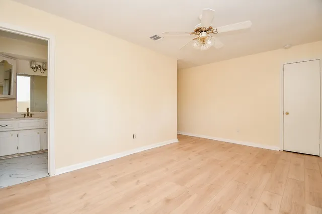 an empty room with a mirror and a fan