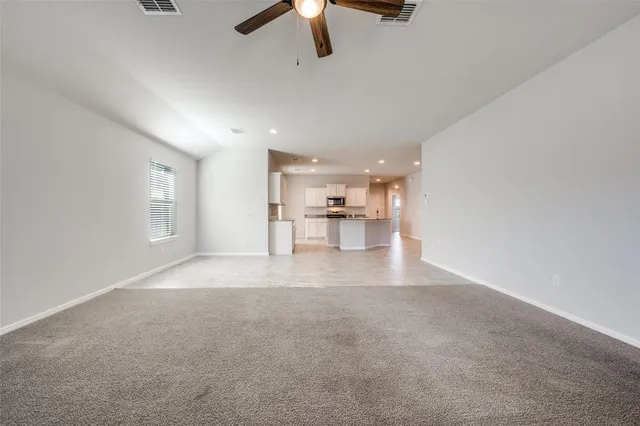 a view of empty room with a kitchen