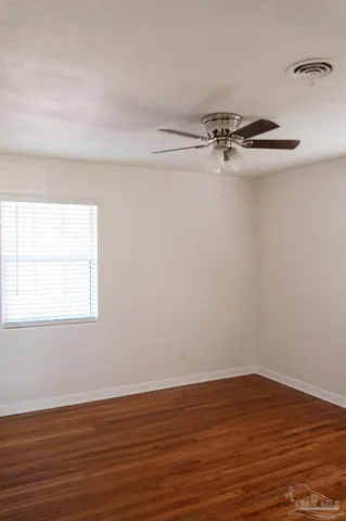 a view of a room with wooden floor and windows