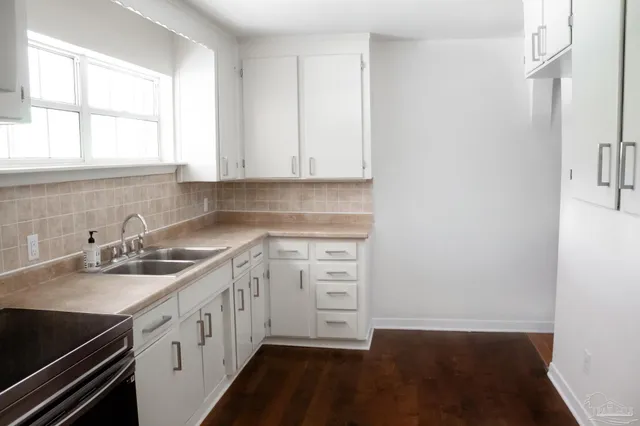 a kitchen with a sink stove and cabinets