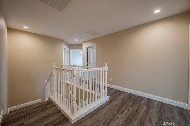 an empty room with a chandelier fan and windows