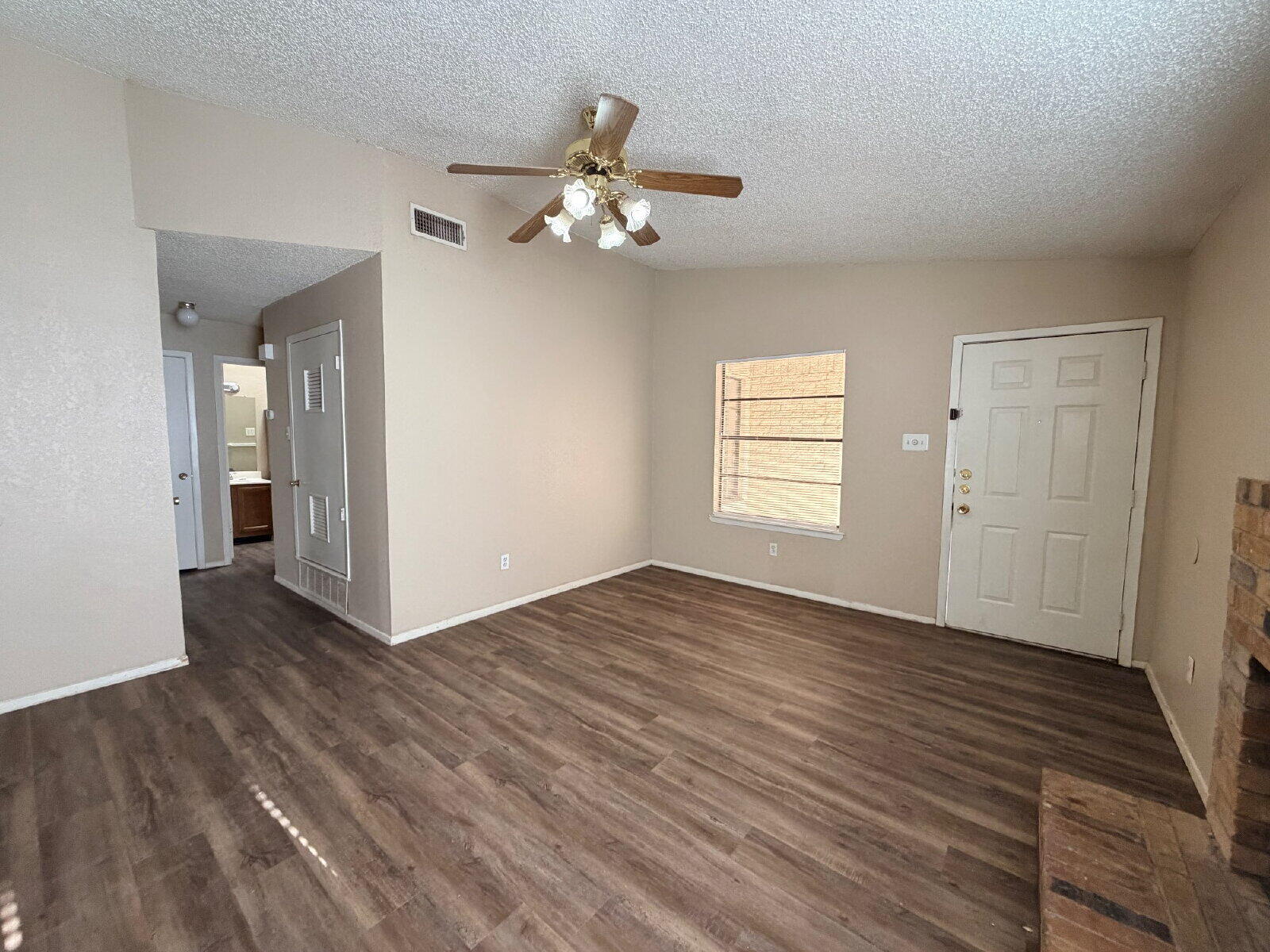 129 North Troy Avenue, Unit B Lubbock, TX 79416 - Photo 3 of 9 a view of an empty room with wooden floor and a window