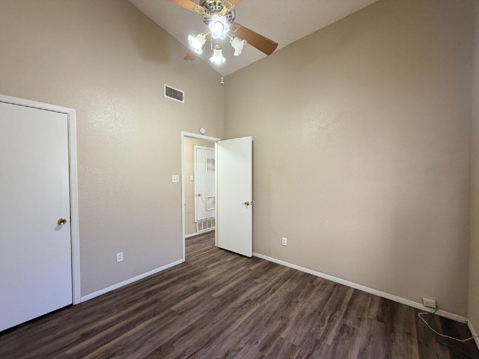 129 North Troy Avenue, Unit B Lubbock, TX 79416 - Photo 5 of 9 an empty room with wooden floor closet and windows