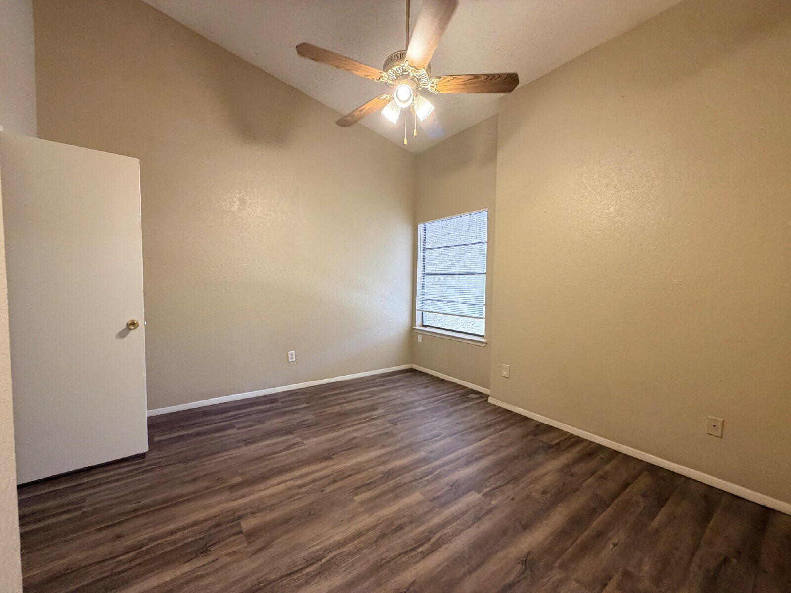 129 North Troy Avenue, Unit B Lubbock, TX 79416 - Photo 7 of 9 an empty room with wooden floor and windows