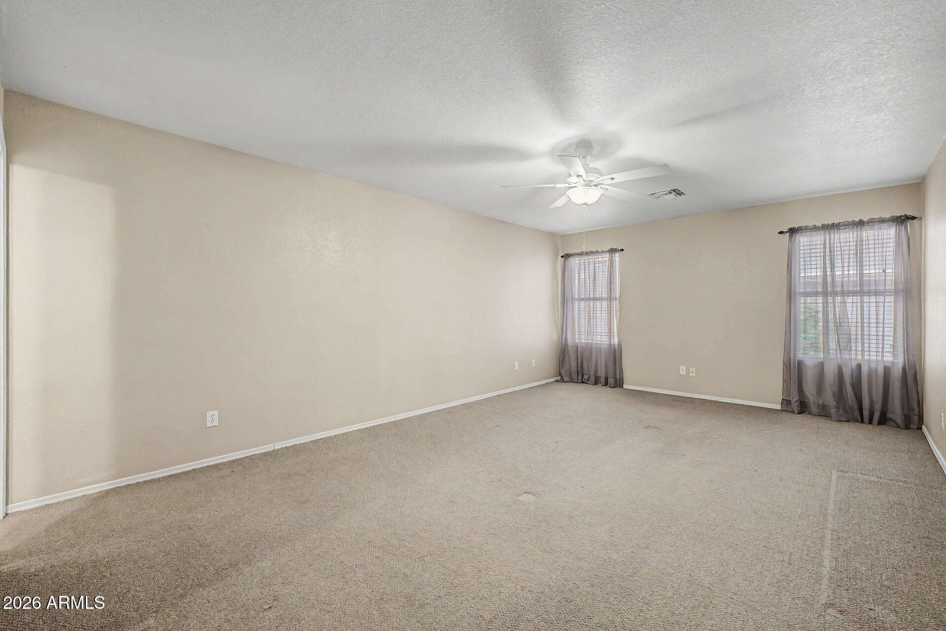 3489 South Bowman Road Apache Junction, AZ 85119 - Photo 17 of 24 an empty room with chandelier fan and windows