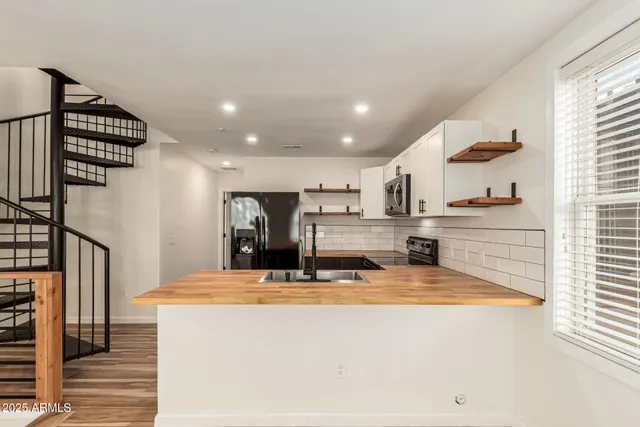 a view of kitchen with stainless steel appliances kitchen island sink refrigerator and stove