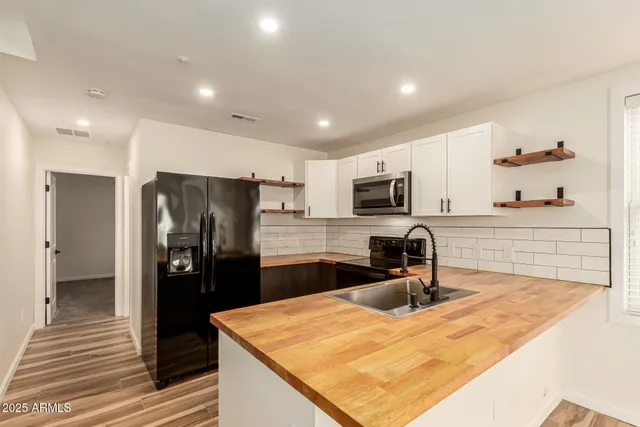 a kitchen with stainless steel appliances granite countertop a refrigerator and a sink