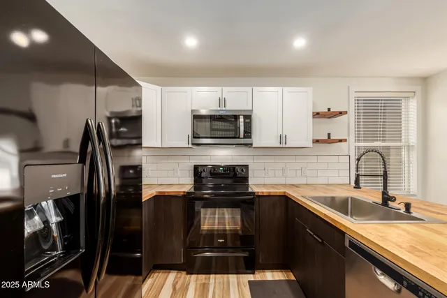 a kitchen with a sink stainless steel appliances and cabinets