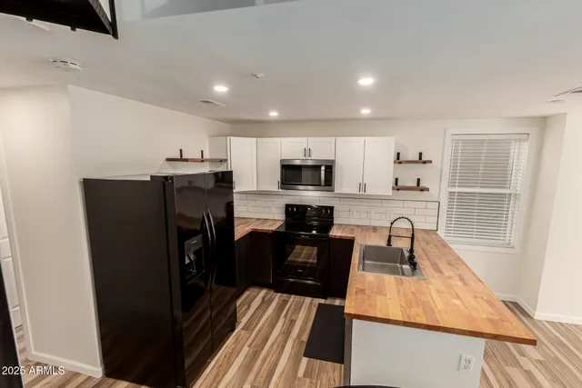 a kitchen with a refrigerator a sink and wooden cabinets