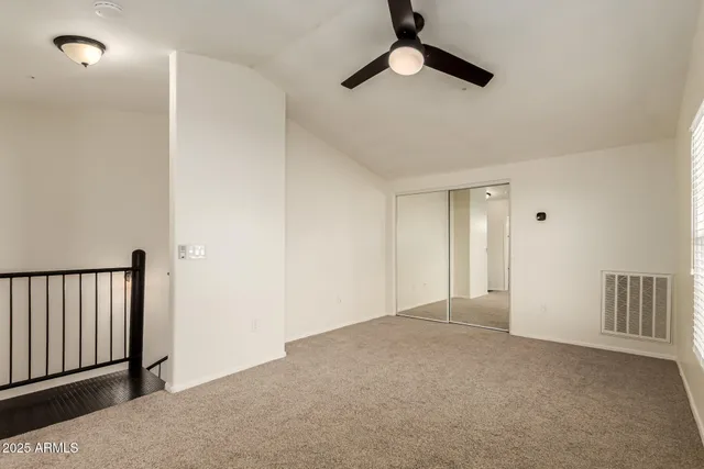 an empty room with chandelier fan