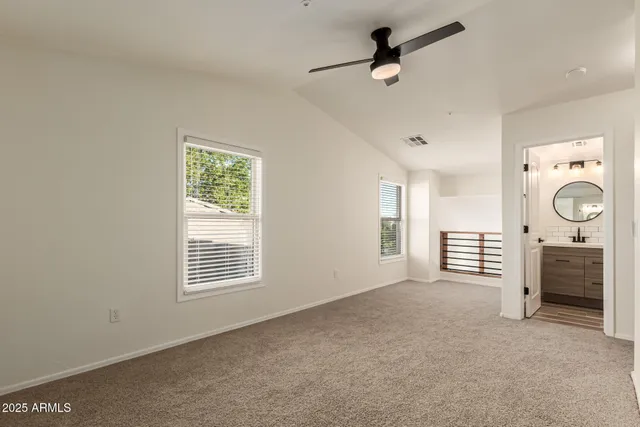 a view of a livingroom with furniture a ceiling fan and windows