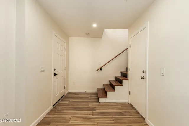 a view of a hallway with wooden floor and staircase
