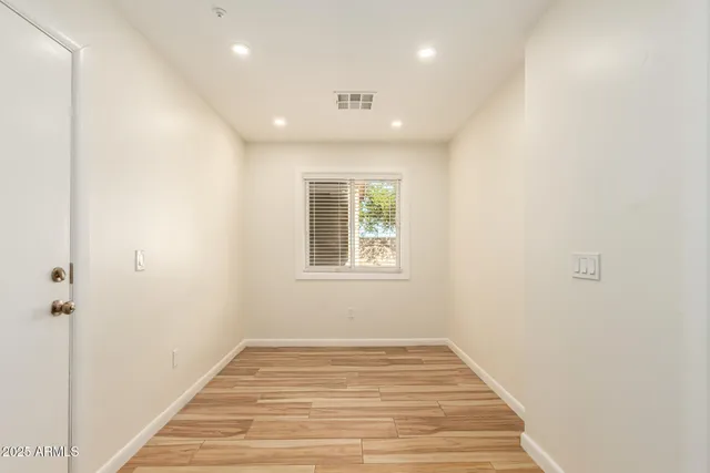 a view of a hallway with wooden floor and a window