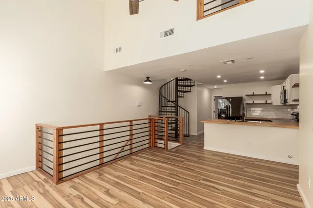 a view of a living room with kitchen furniture and a wooden floor