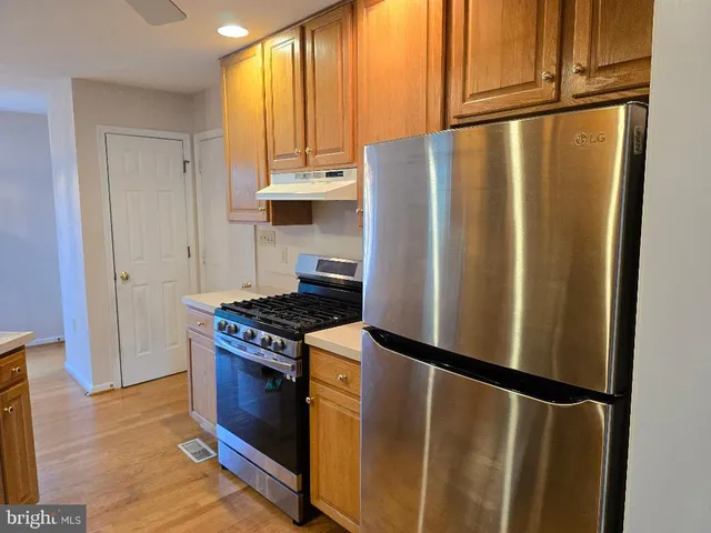 a kitchen with stainless steel appliances granite countertop a refrigerator a stove and a cabinets