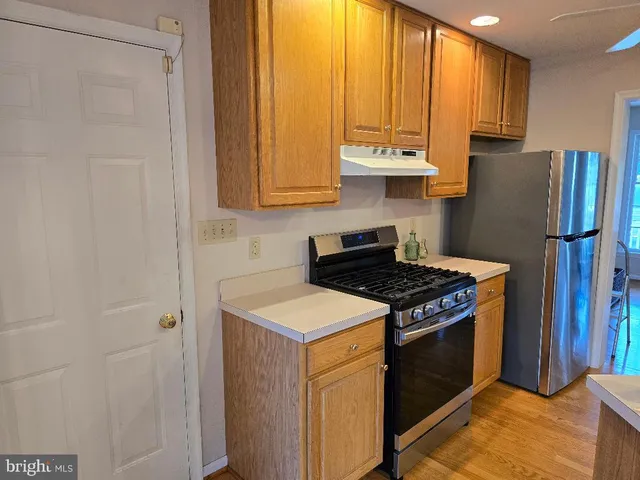 a kitchen with stainless steel appliances granite countertop a stove a refrigerator and a sink