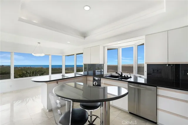 a kitchen with a sink and chairs