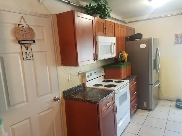 a kitchen with stainless steel appliances granite countertop a stove a refrigerator and a microwave