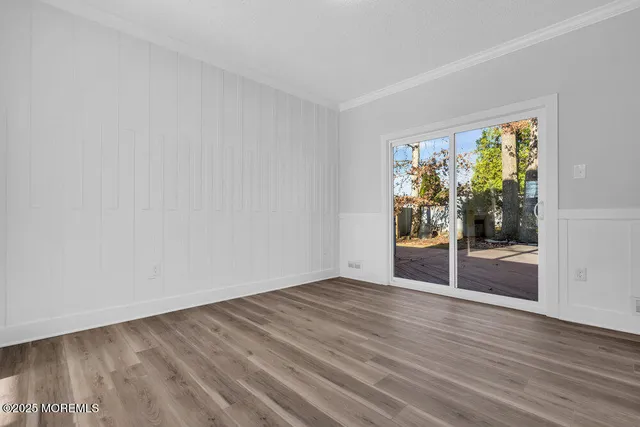 a kitchen with stainless steel appliances granite countertop a refrigerator a sink a stove and white cabinets with wooden floor