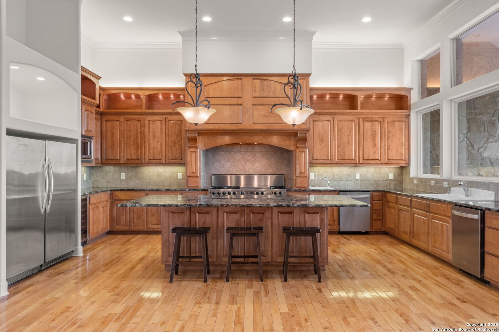1069 Fawn River Drive Spring Branch, TX 78070 - Photo 9 of 25 a kitchen with kitchen island granite countertop wooden floors stainless steel appliances a sink and a center island