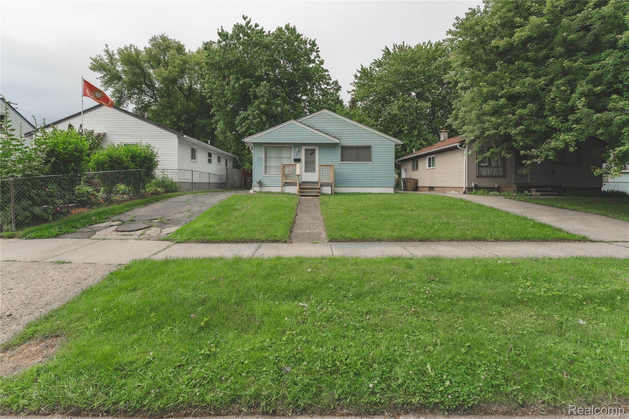 93 West Princeton Avenue Pontiac, MI 48340 - Photo 2 of 31 Single-story residence featuring light blue siding, a front porch with white railings, and a concrete pathway