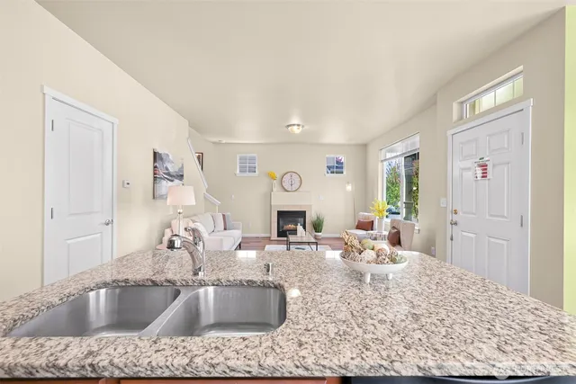 a kitchen with kitchen island a sink stove and view living room