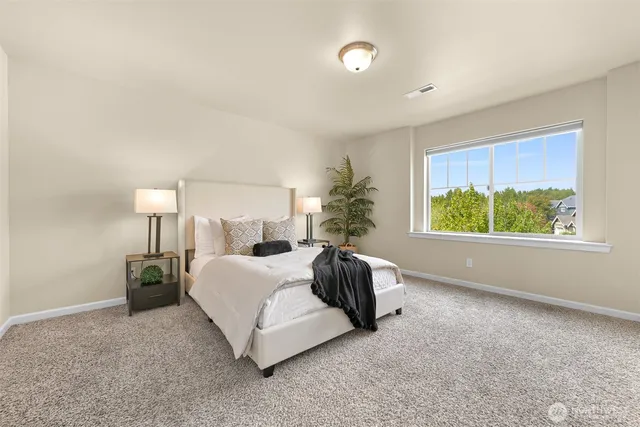 a spacious bedroom with a bed and window