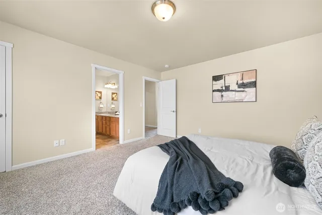 a bedroom with a bed and a lamp on the dresser