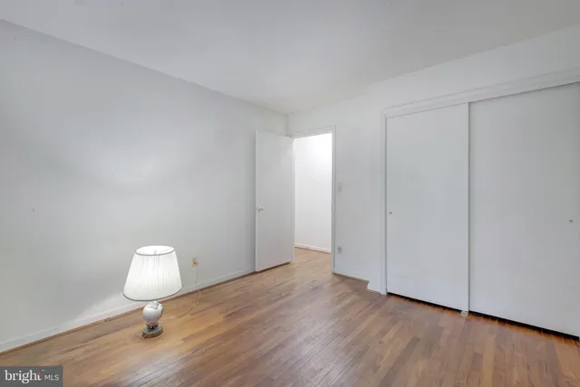 a view of a room with wooden floor and mirror