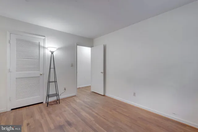 an empty room with wooden floor and mirror