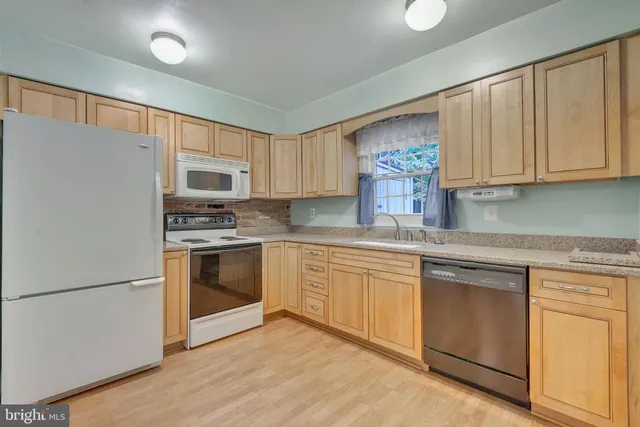 a kitchen with granite countertop white cabinets and white appliances