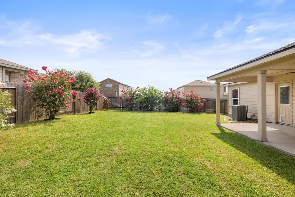 217 Farmer Lane Jarrell, TX 76537 - Photo 26 of 29 A spacious, enclosed backyard offers ample space and blooming crepe myrtles.