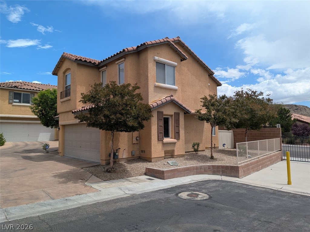 10308 Faustine Avenue Las Vegas, NV 89129 - Photo 2 of 28 A terracotta-roofed residence boasts an attached garage and desert-friendly landscaping.