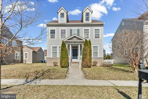 front view of a brick house with a yard