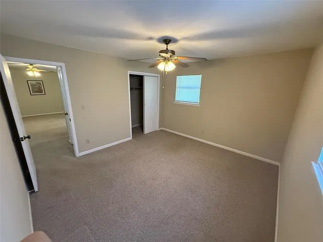 an empty room with closet and windows