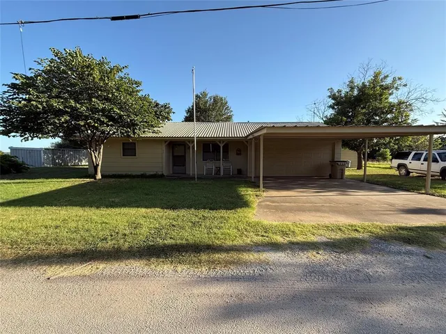 a front view of a house with a yard and potted plants