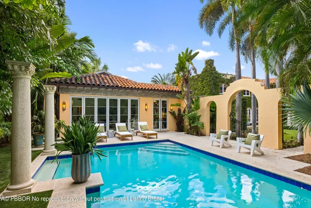 a view of a backyard with swimming pool and sitting area