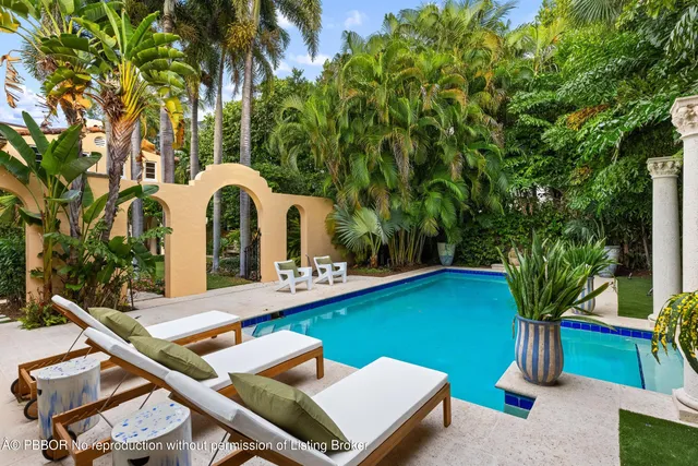 a front view of a building with a garden and plants