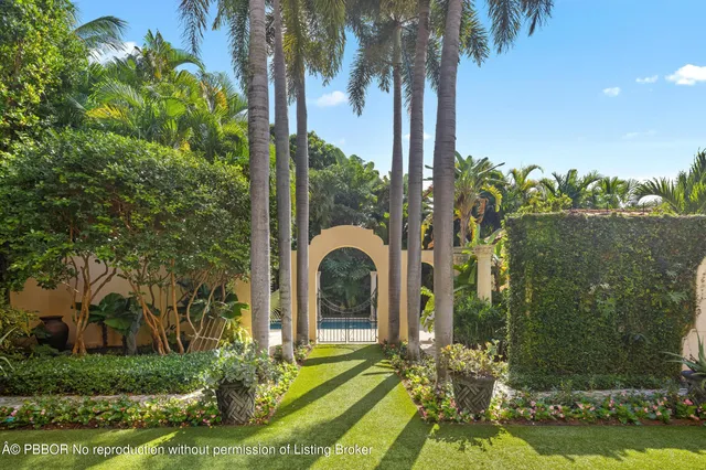 a front view of a house with a yard and potted plants