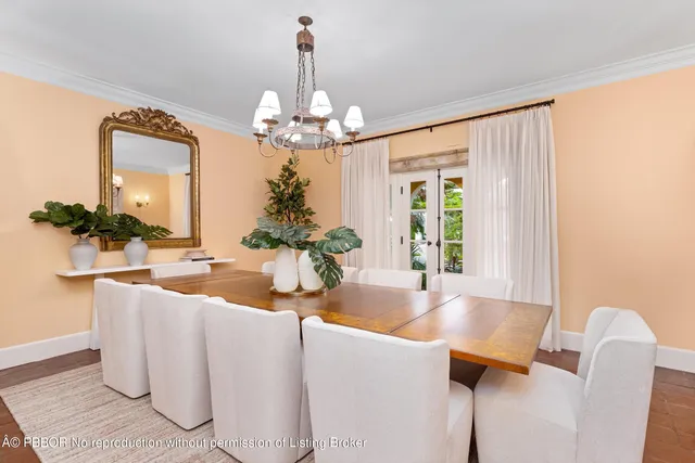 a dining room with furniture a chandelier and window
