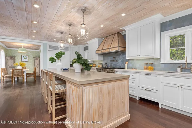 a kitchen with kitchen island granite countertop a white cabinets and chairs